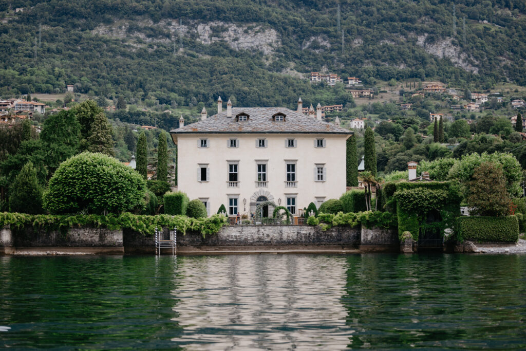 Die 10 schönsten Hochzeitslocations am Comer See 10 Große weiße Villa mit Bogenfenstern und Gärten an einem ruhigen See, umgeben von bewaldeten Hügeln - ein idyllischer Drehort für Fotografie oder eine unvergessliche Hochzeit im Ausland.