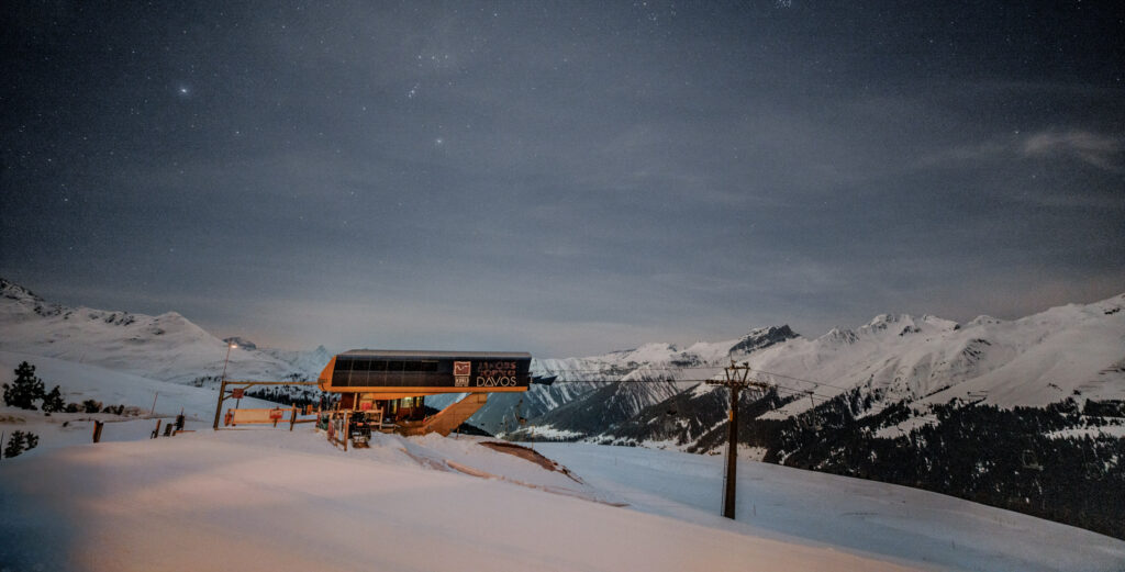 Winterhochzeit in den Schweizer Alpen 3 Eine Skiliftstation in den verschneiten Bergen unter einem klaren, sternenklaren Nachthimmel - eine ideale Filmkulisse für eine Luxus Hochzeit im Ausland.