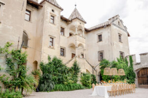 Ein eleganter Esstisch im Freien, der vor einem alten, efeubewachsenen Gebäude im europäischen Stil gedeckt wird, ist das perfekte Luxusziel für eine Hochzeit im Ausland.