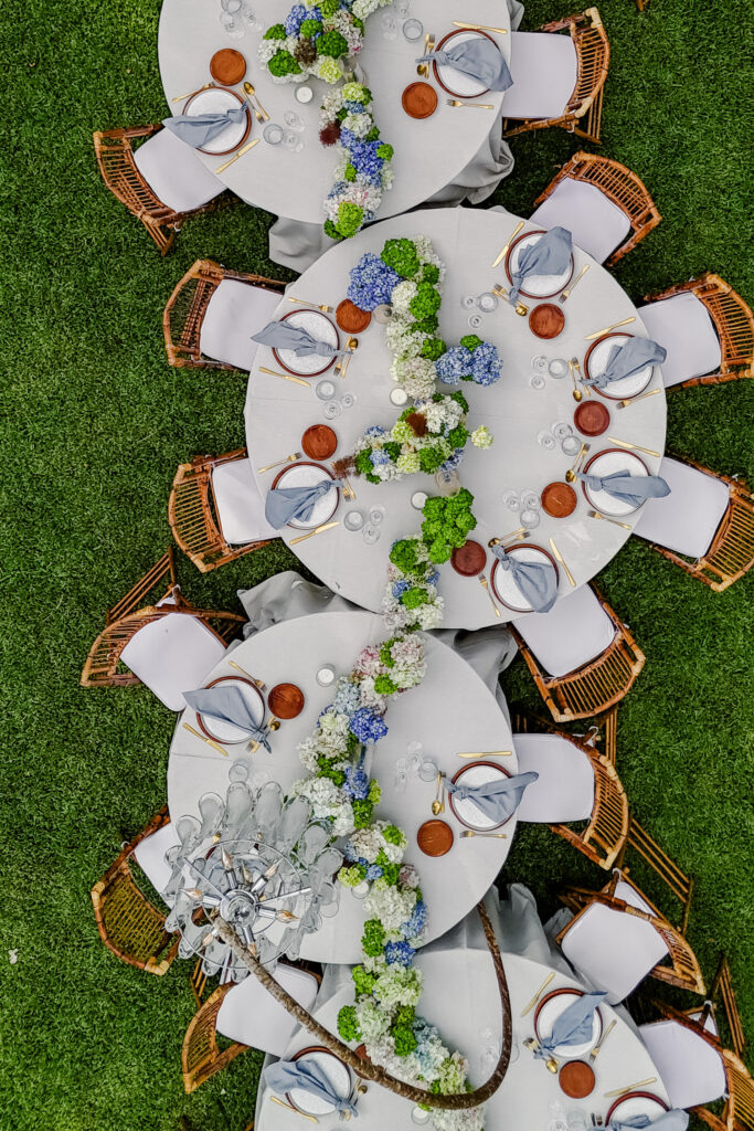 Luftaufnahme von runden Tischen im Freien mit Blumenschmuck