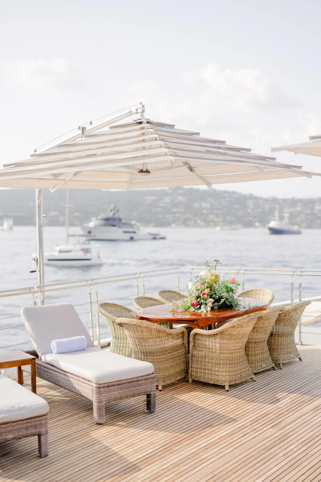 Wedding Photography South France 20 Esstisch mit Blumengesteck und Liegestühlen auf dem Deck einer Yacht.