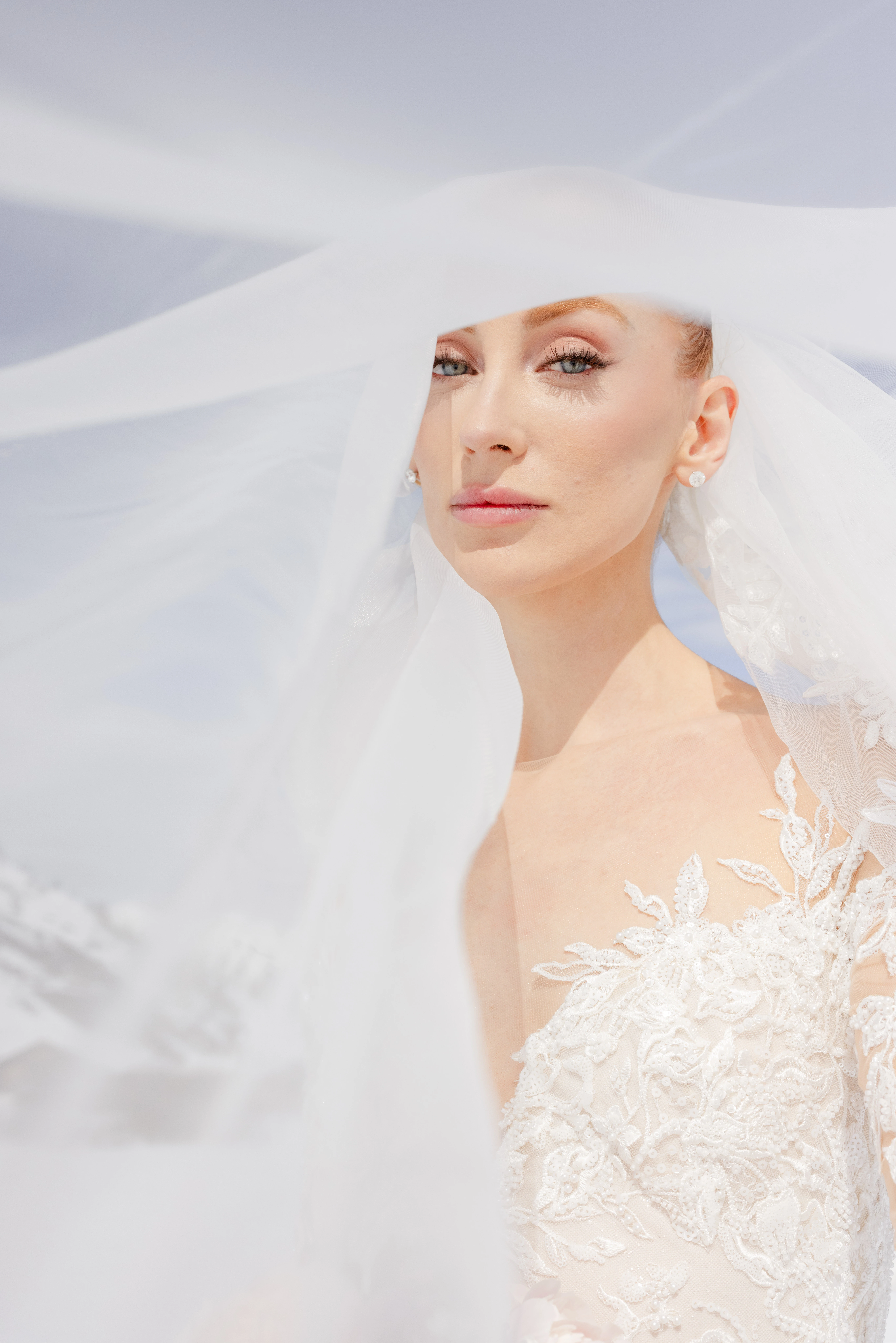 A bride looking through a transparent lace veil.