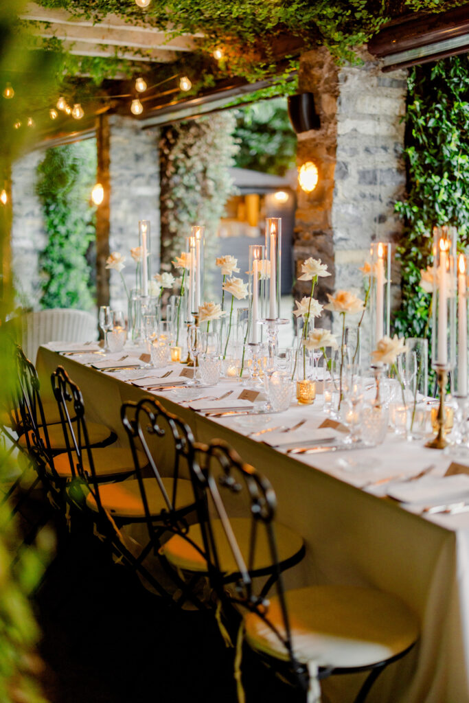 Hochzeitslocation Relais Villa Vittoria am Comer See – Intime Hochzeit in einer historischen Villa 5 Ein langer Banketttisch, gedeckt für eine Dinnerparty mit hohen Kerzen und Blumengestecken als Tischdekoration.