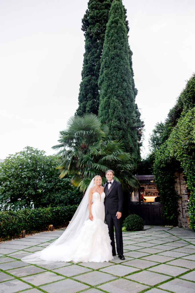 Hochzeitslocation Relais Villa Vittoria am Comer See – Intime Hochzeit in einer historischen Villa 15 Ein Brautpaar in Hochzeitskleidung steht auf einer Steinterrasse im Relais Villa Vittoria.